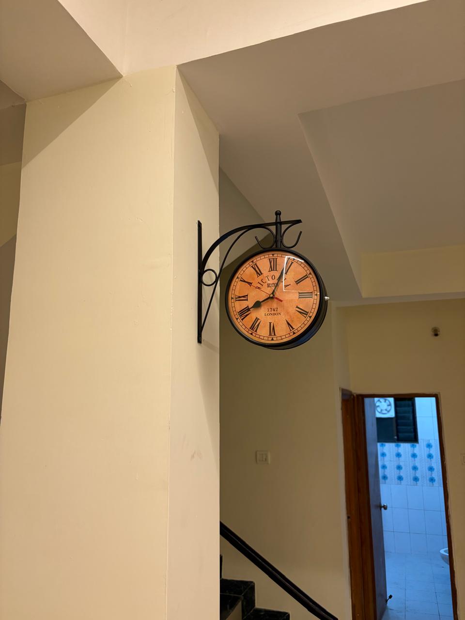 Vintage-style wall clock decor in the stairwell hallway