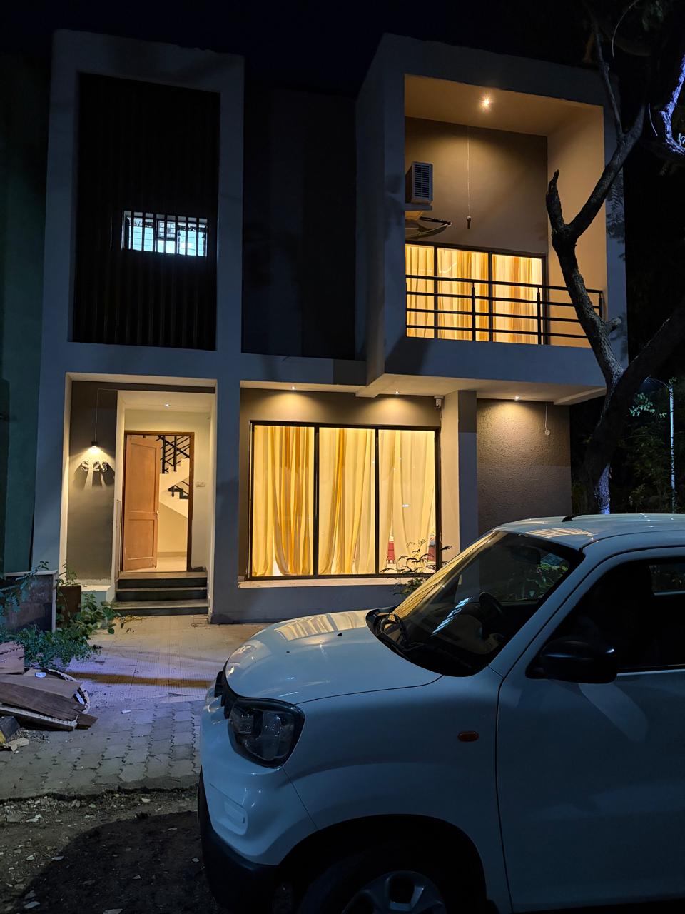 Nature Bliss Homestay exterior at night with warm lighting and covered parking