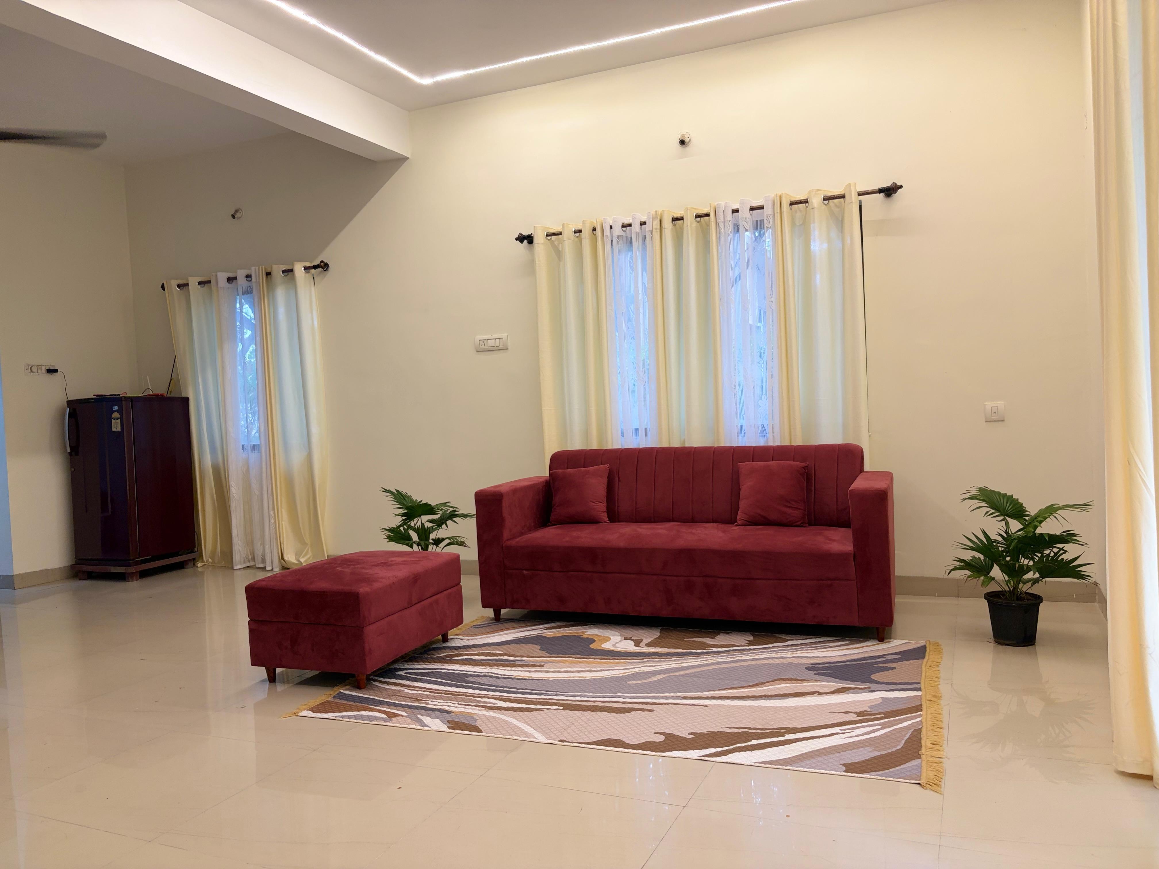 Living room with maroon sofa and patterned rug