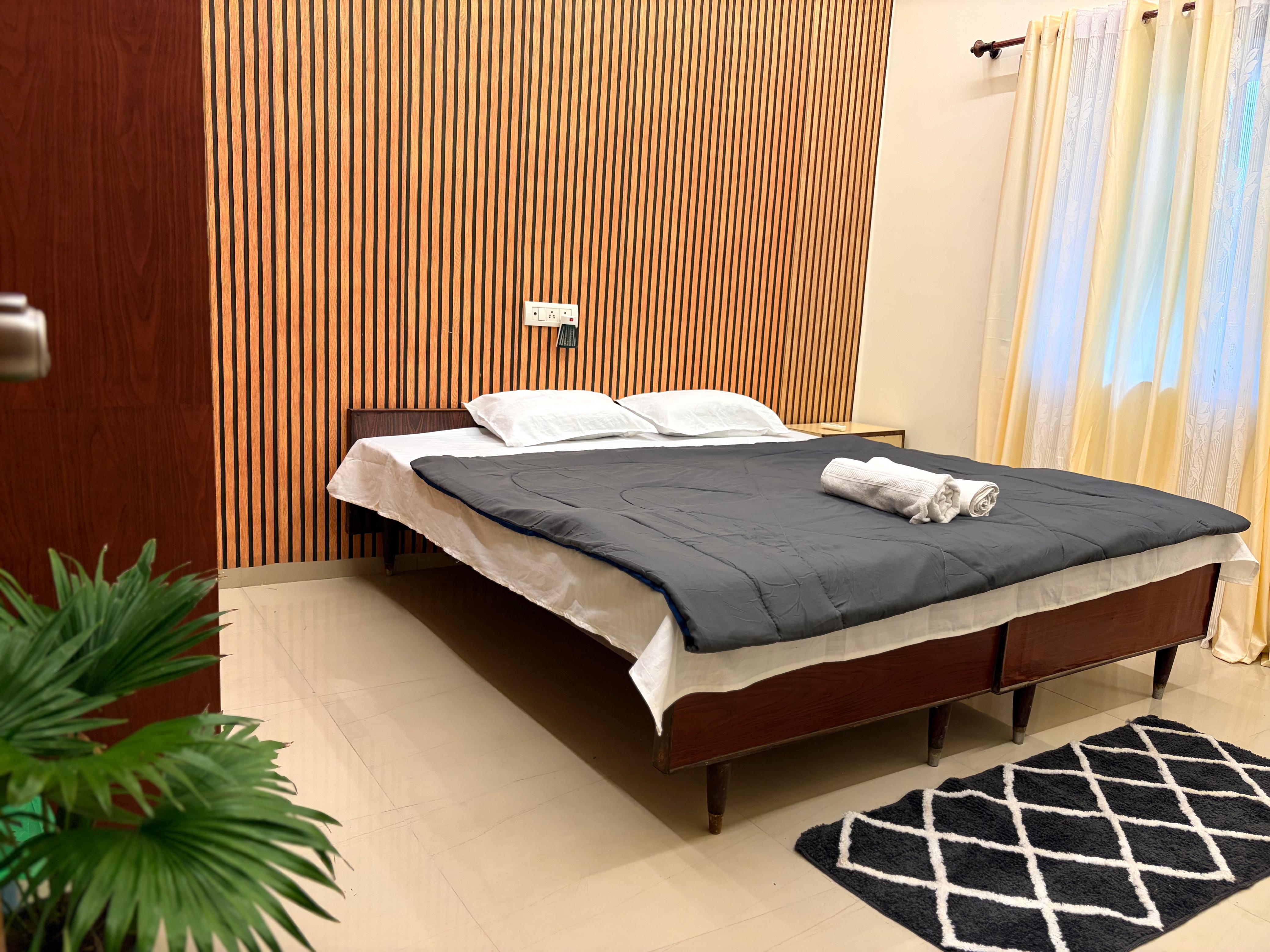 Bedroom with wood-paneled headboard and charcoal bedspread